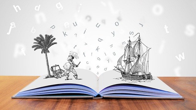 Auf einem geöffneten Buch stehen ein gemalter Pirat und ein gemaltes Schiff.